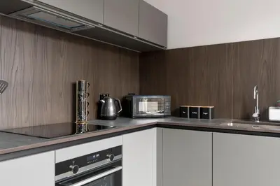a kitchen with white cabinets and a counter top with a microwave at Modern George Street Studio sleeping 2 in Edinburgh