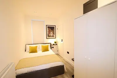 a bedroom with a bed with yellow pillows at City Centre Hub Stirling, On Street Parking. in Stirling