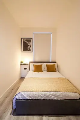 a bedroom with a large bed with yellow pillows at City Centre Hub Stirling, On Street Parking. in Stirling