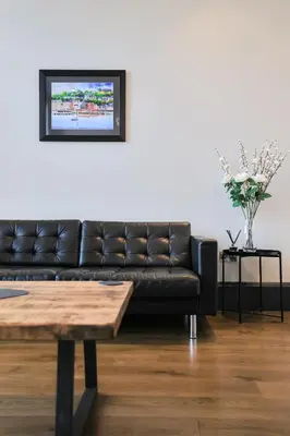 a black leather couch in a living room with a table at Campbell Street Apartments in Oban