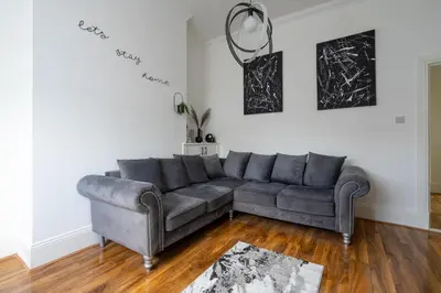 a living room with a gray couch in a room at Coatbridge Apartment in Coatbridge