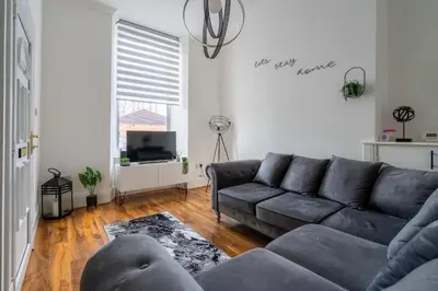 a living room with a couch and a tv at Coatbridge Apartment in Coatbridge