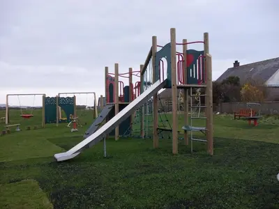 a playground with a slide in the grass at Inishroel Cottage in Campbeltown