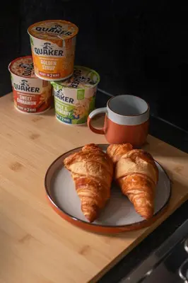 a table with a plate of croissants and a cup of coffee at Trendy 2 Bed Flat - Near Airport in Broxburn