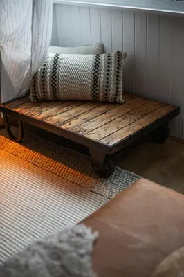 a wooden bench with two pillows sitting on it at Trendy 2 Bed Flat - Near Airport in Broxburn