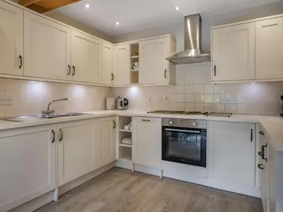 a kitchen with white cabinets and a sink and a stove at 1 Bed in Callander oc-pe173 in Strathyre