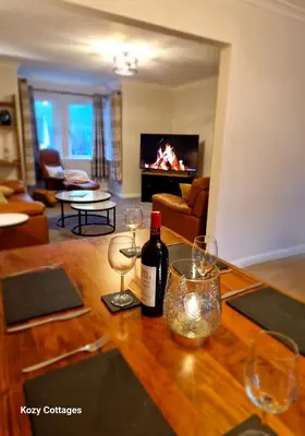 a bottle of wine on a table in a living room at Ben Arthur Apartment in Lochgoilhead
