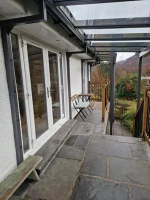 a patio with a bench on the side of a house at Langview in Arrochar