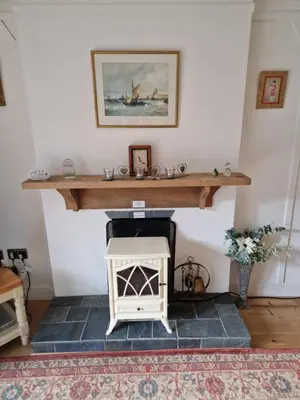a living room with a fireplace and a wooden table at Langview in Arrochar