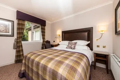 a hotel room with a bed and a window at Macdonald Inchyra Hotel & Spa in Falkirk