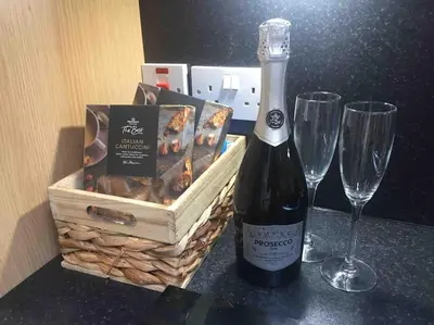 a bottle of wine and two wine glasses on a counter at Wardie Garden Cottage in Edinburgh