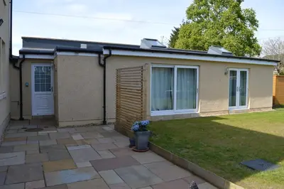 a house with a pitched roof and a yard at Wardie Garden Cottage in Edinburgh