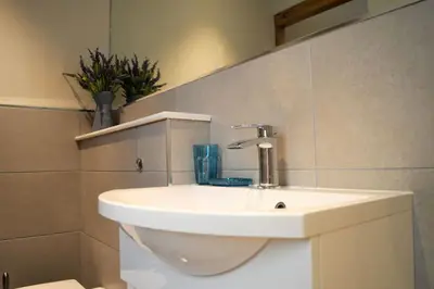 a bathroom with a white sink and aflush at Wardie Garden Cottage in Edinburgh