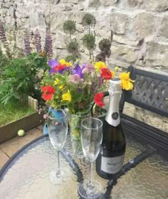 a bottle of champagne and two glasses of flowers at Wardie Garden Cottage in Edinburgh