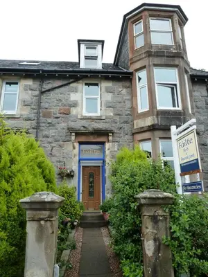 an old stone house with a blue door at Failte Bed & Breakfast in Oban