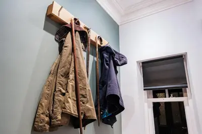 a rack of clothes hanging on a wall next to a window at The Old School House, luxury home with hot tub. in Minnigaff