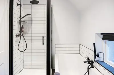 a bathroom with a shower with a glass door at The Old School House, luxury home with hot tub. in Minnigaff