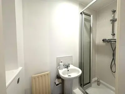 a white bathroom with a sink and a shower at Private room with en-suite and parking in shared flat in Glasgow