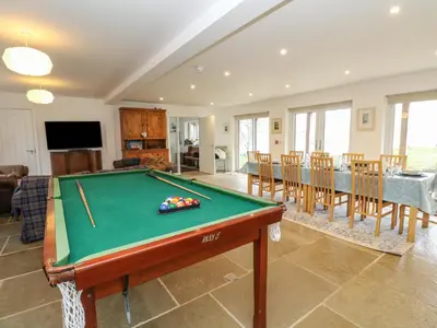 a living room with a pool table and a dining room at The Pier House in Lochgilphead