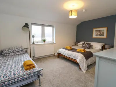 a bedroom with two beds and a window at The Pier House in Lochgilphead