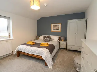 a bedroom with a bed with yellow towels on it at The Pier House in Lochgilphead