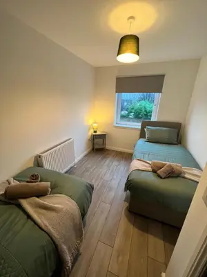 a bedroom with two beds and a window at Inchcailloch Townhouse, Loch Lomond in Bonhill
