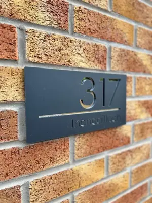 a sign on the side of a brick wall at Inchcailloch Townhouse, Loch Lomond in Bonhill