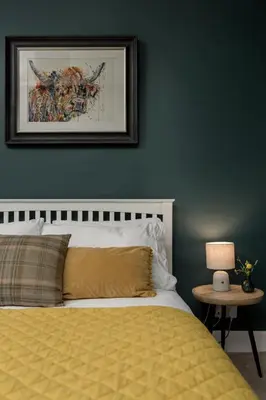 a bedroom with a yellow bed and a picture on the wall at Rose Apartment in Edinburgh