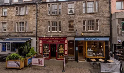 a brick building with a store in front of it at Rose Apartment in Edinburgh