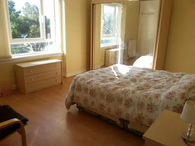 a bedroom with a bed and two windows at Comfortable Rooms With Work Desks In Cheerful Apartment Glasgow City in Glasgow