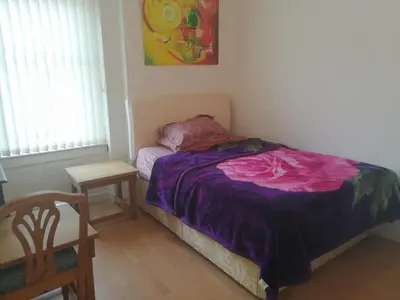 a bedroom with a bed and a table and a chair at Comfortable Rooms With Work Desks In Cheerful Apartment Glasgow City in Glasgow
