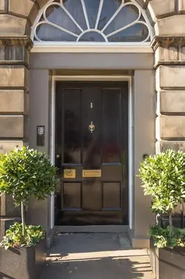 a black door of a building with two plants at Prime Edinburgh City Centre - 4 Bed Penthouse in Edinburgh