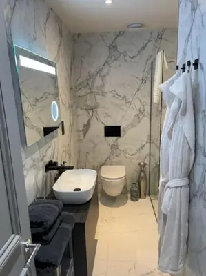 a marble bathroom with a sink and a toilet at Complete City Centre Comfort in Edinburgh