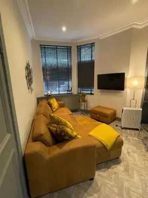 a living room with a couch and a flat screen tv at Complete City Centre Comfort in Edinburgh