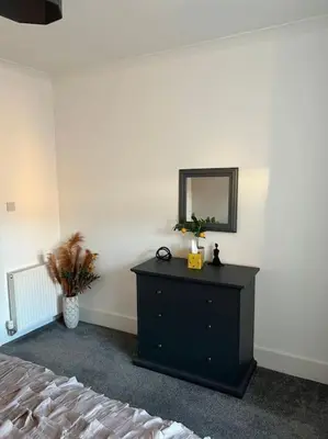 a bedroom with a dresser with a mirror and a bed at Newly refurbished flat - Callander in Callander