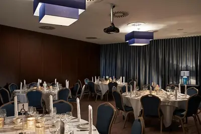 a conference room with tables and chairs and chandeliers at Village Hotel Edinburgh in Edinburgh