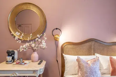 a bedroom with a bed with a mirror and a table at Boutique Home Stay Blossom in Paisley