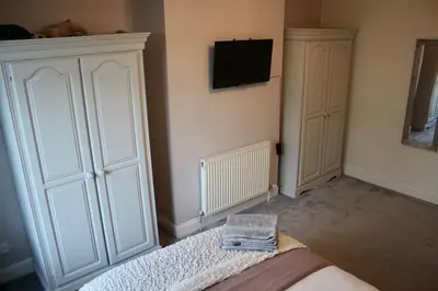 a bedroom with a bed and a tv on the wall at Amazing 2-Bed Home w/ Private Garden Free Parking in Cardonald