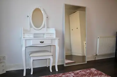 a white dressing table with a mirror and a chair at Amazing 2-Bed Home w/ Private Garden Free Parking in Cardonald