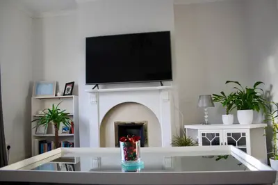 a living room with a fireplace with a flat screen tv at Amazing 2-Bed Home w/ Private Garden Free Parking in Cardonald