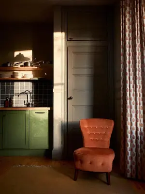 a kitchen with an orange chair and a door at Jameswood Villa in Sandbank