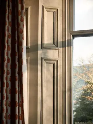 a window with a curtain in front of a window at Jameswood Villa in Sandbank