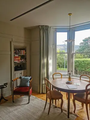 a living room with a table and chairs and a window at Jameswood Villa in Sandbank