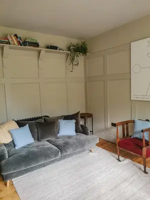 a living room with a gray couch and a chair at Jameswood Villa in Sandbank