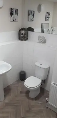 a white bathroom with a toilet and a sink at Spacious Modern Apartment in Glasgow