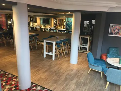 a bar with chairs and tables in a room at Holiday Inn Glasgow - East Kilbride by IHG in East Kilbride