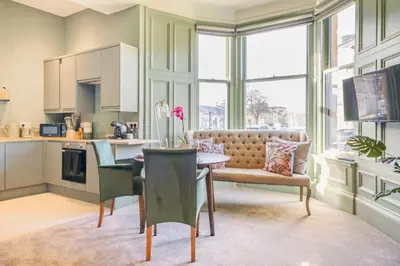 a kitchen and dining room with a table and chairs at Boutique Home Stay - Bliss Studio in Paisley