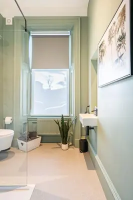 a bathroom with a sink and a toilet and a window at Boutique Home Stay - Bliss Studio in Paisley