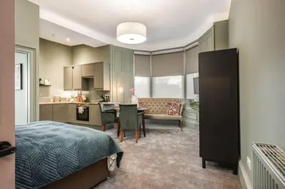 a bedroom with a bed and a kitchen with a table at Boutique Home Stay - Bliss Studio in Paisley