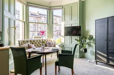 a living room with a table and chairs and a couch at Boutique Home Stay - Bliss Studio in Paisley
